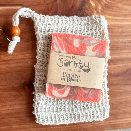 Half size bar of Garden in Bloom goat milk soap laying on top of a sisal soap saver bag. This combination makes a great Valentine's Day gift for teachers and friends!