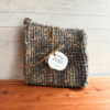 Set of two gray and beige variegated crocheted potholders on a cedar bath board, tied with a piece of twine with a simple brand label.