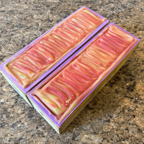 Two freshly poured loaves of Boat Drinks goat milk soap, with pretty swirls of yellow and orange on top.