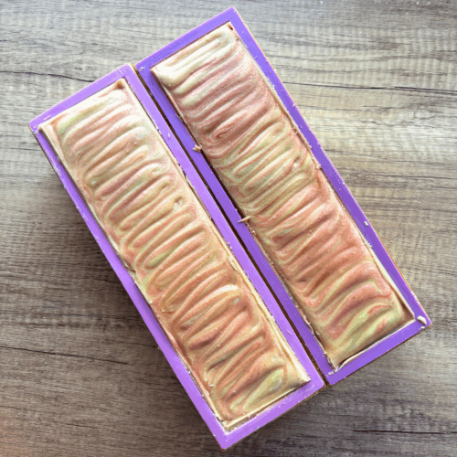 Two loaves of Boat Drinks goat milk soap taken just before cutting into bars, featuring pretty swirls of yellow and orange on top.