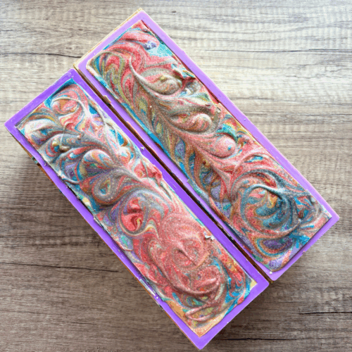 Two loaves of Stronger Together goat milk soap pictured just before cutting into loaves. The colorful swirls on top are perfect for celebrating Pride Month with this artisan soap.