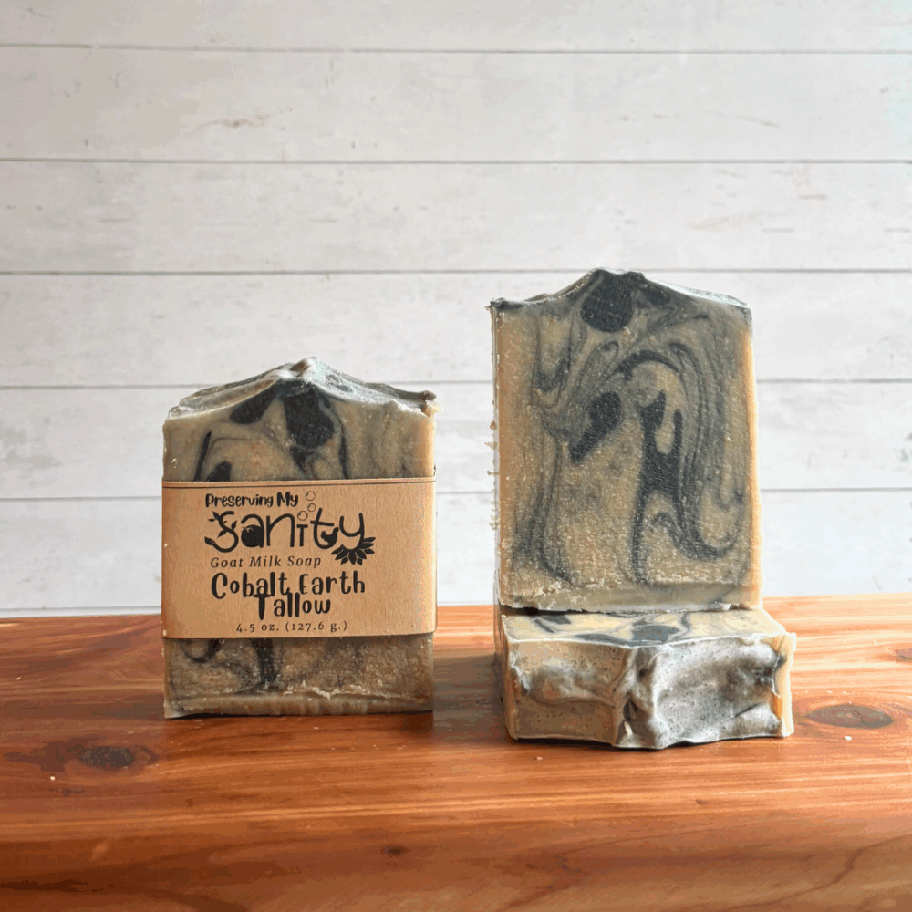 Three bars of cobalt earth tallow soap made with essential oils of patchouli, bergamot, and cedarwood. The soap is colored with natural colorants of indigo and charcoal in a pretty swirl pattern.